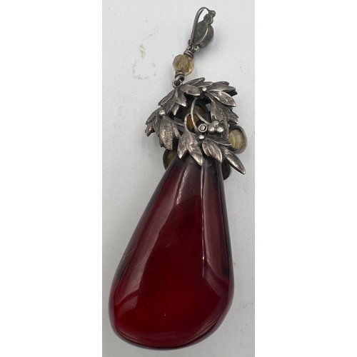 375 - White metal mounted cherry amber drop pendant the mount set with gems to include moonstones. Weight ... 