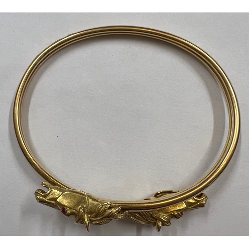 377 - A 18 carat gold horse head bangle with ruby eyes. Weight 22.7gm.