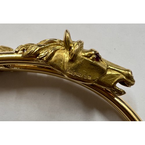 377 - A 18 carat gold horse head bangle with ruby eyes. Weight 22.7gm.