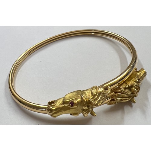 377 - A 18 carat gold horse head bangle with ruby eyes. Weight 22.7gm.