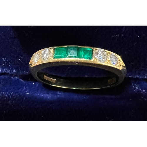 404 - An 18 carat gold ring set with diamonds and emeralds. Size L. Weight 2.6gm.