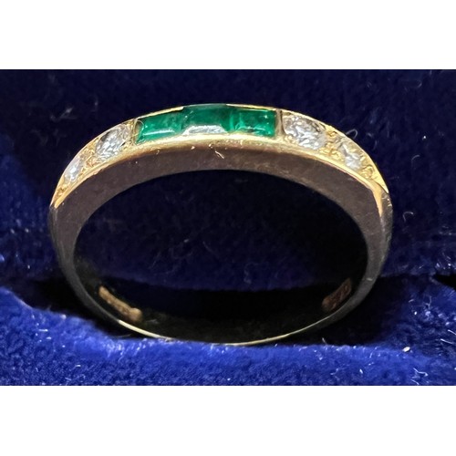 404 - An 18 carat gold ring set with diamonds and emeralds. Size L. Weight 2.6gm.