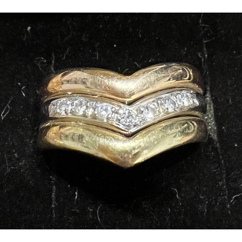 406 - A 18 carat white and yellow gold ring set with a v shaped band of diamonds. Weight 5.3gm. Size M.