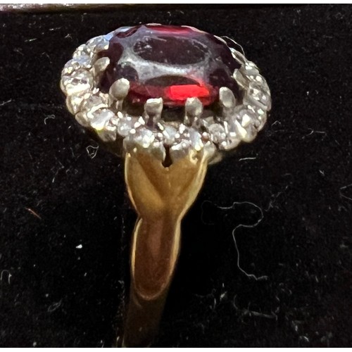 411 - An 18 carat gold ring set with red stone surrounded by diamonds. Size M. Weight 4.2gm.