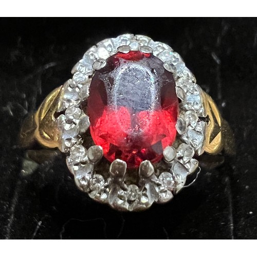 411 - An 18 carat gold ring set with red stone surrounded by diamonds. Size M. Weight 4.2gm.