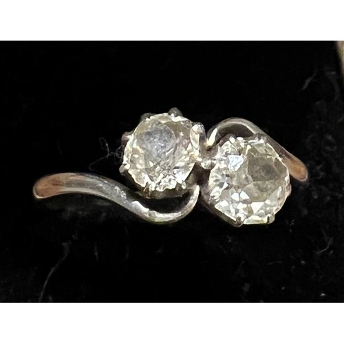 412 - A platinum ring set with two diamonds in a crossover setting. Size P. Weight 3.6gm.