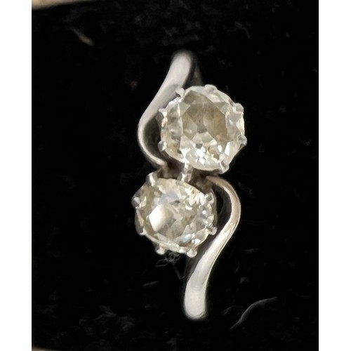 412 - A platinum ring set with two diamonds in a crossover setting. Size P. Weight 3.6gm.