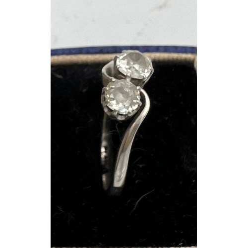 412 - A platinum ring set with two diamonds in a crossover setting. Size P. Weight 3.6gm.