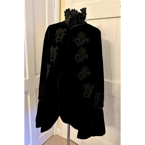 938 - A Victorian black velvet cape with stand up taffeta collar and applied decoration. Back of neck to h... 