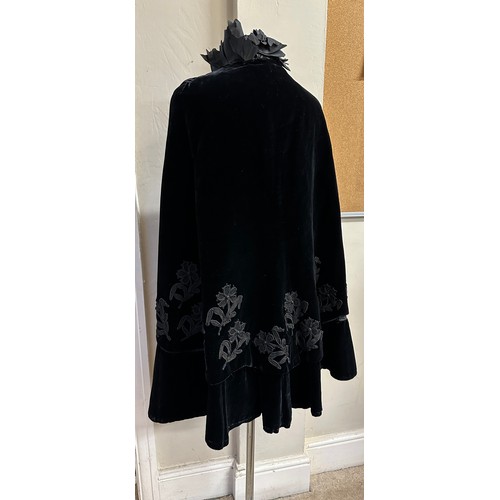 938 - A Victorian black velvet cape with stand up taffeta collar and applied decoration. Back of neck to h... 