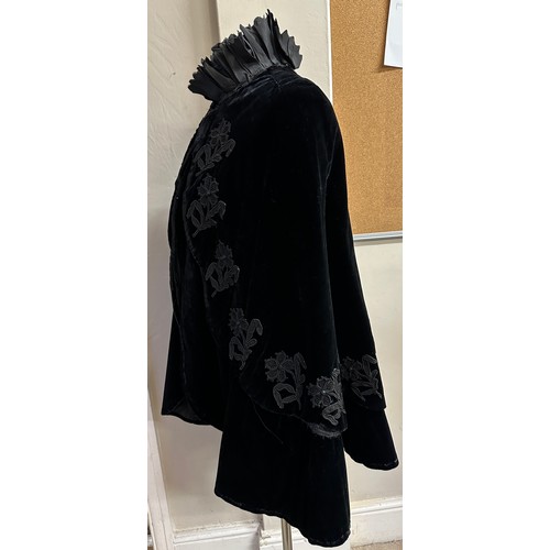 938 - A Victorian black velvet cape with stand up taffeta collar and applied decoration. Back of neck to h... 