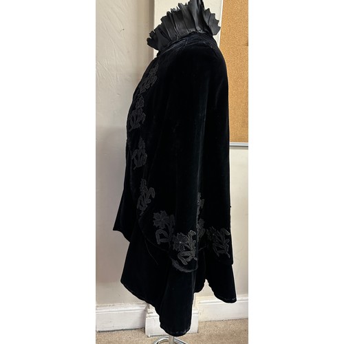 938 - A Victorian black velvet cape with stand up taffeta collar and applied decoration. Back of neck to h... 