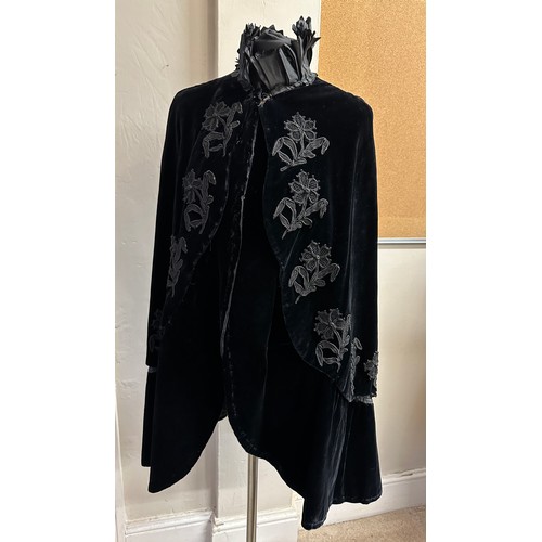 938 - A Victorian black velvet cape with stand up taffeta collar and applied decoration. Back of neck to h... 