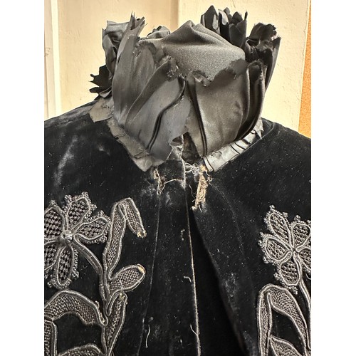 938 - A Victorian black velvet cape with stand up taffeta collar and applied decoration. Back of neck to h... 