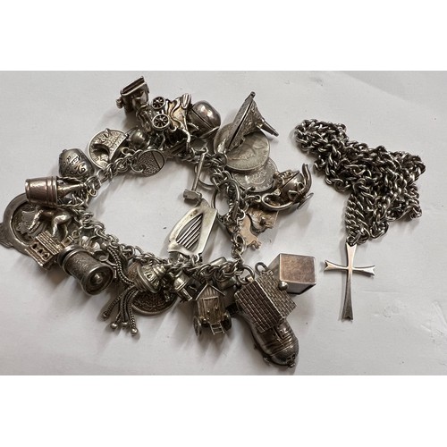 363 - A silver charm bracelet and multiple charms together with .925 crucifix on chain. Total weight 142.6... 