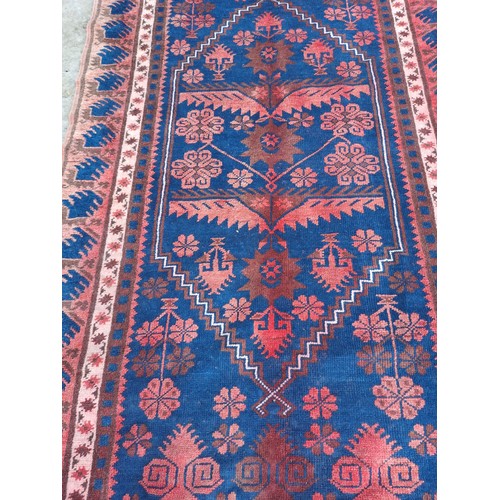 1239 - A good quality rug in shades of blue and red. 290cm x 80cm.