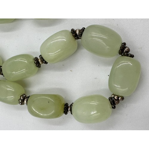 360 - A light green jade necklace and matching bracelet with silver beads and fastening, 42cm l and 22cm l... 