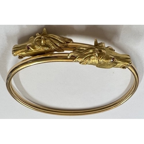 377 - A 18 carat gold horse head bangle with ruby eyes. Weight 22.7gm.