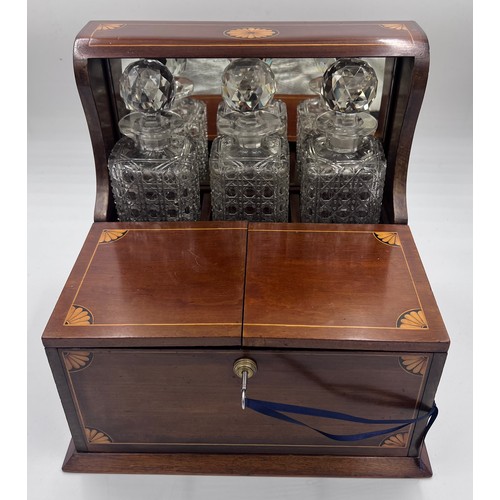 1274A - An Edwardian mahogany inlaid cut glass tantalus and games box containing cigar cutter, silver plated... 