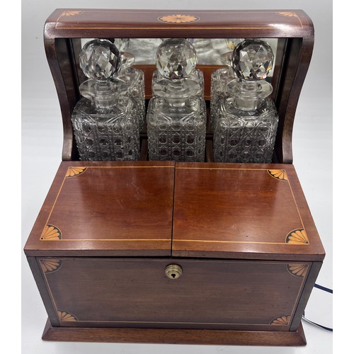 1274A - An Edwardian mahogany inlaid cut glass tantalus and games box containing cigar cutter, silver plated... 