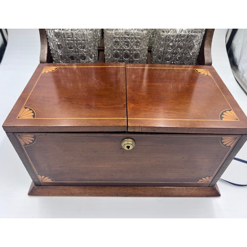 1274A - An Edwardian mahogany inlaid cut glass tantalus and games box containing cigar cutter, silver plated... 