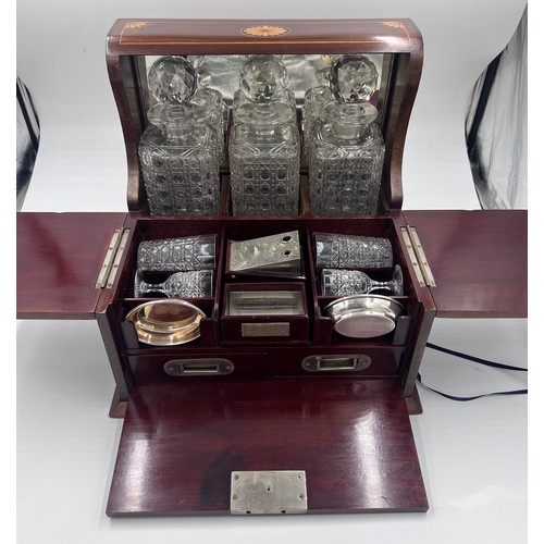 1274A - An Edwardian mahogany inlaid cut glass tantalus and games box containing cigar cutter, silver plated... 