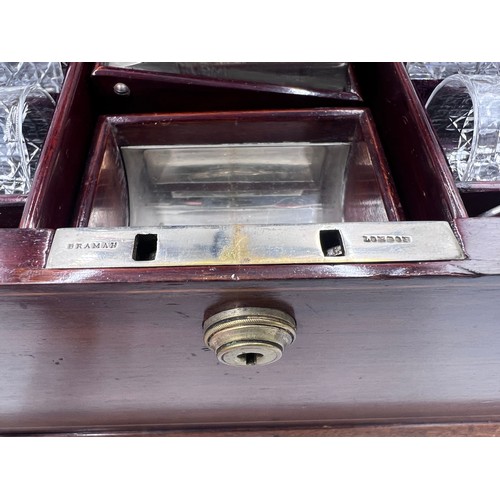 1274A - An Edwardian mahogany inlaid cut glass tantalus and games box containing cigar cutter, silver plated... 