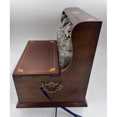 1274A - An Edwardian mahogany inlaid cut glass tantalus and games box containing cigar cutter, silver plated... 