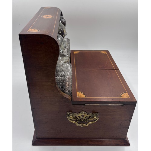 1274A - An Edwardian mahogany inlaid cut glass tantalus and games box containing cigar cutter, silver plated... 