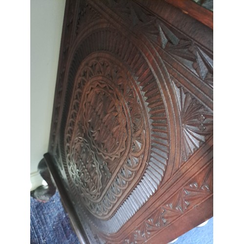 69 - A very highly carved hardwood display cabinet/ bookcase, three glazed doors over a base of drawers a... 