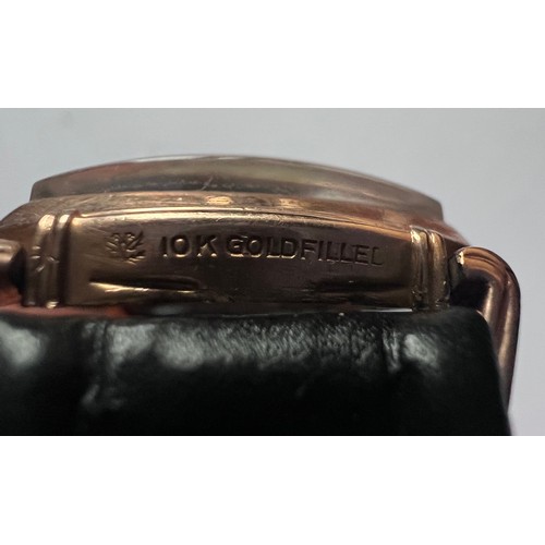 553 - A 10ct gold filled bezel vintage Westfield (Bulova) wristwatch on black leather strap. Case 25mm. 

... 