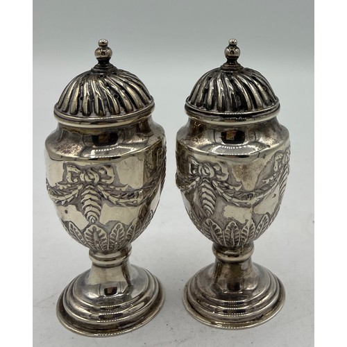 701 - A pair of silver pepperettes, Sheffield 1897, maker Walker and Hall. Weight 155gm. Height 10.5cm.