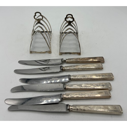 703 - A pair of silver toast racks, weight 79gm and six silver handled dessert knives, both Birmingham 193... 