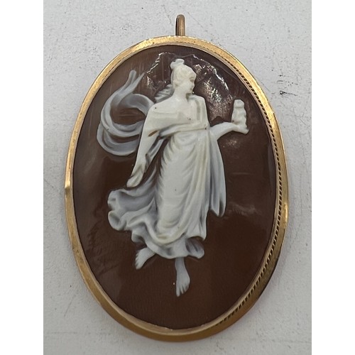 448 - A carved shell cameo locket/brooch mounted in unmarked yellow metal. Size 4cm x 3cm.