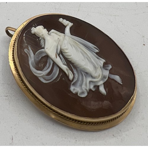 448 - A carved shell cameo locket/brooch mounted in unmarked yellow metal. Size 4cm x 3cm.