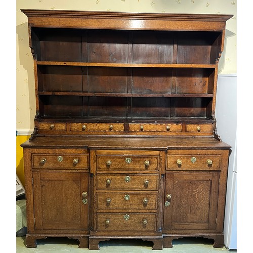 76 - Georgian oak dresser with break front base on bracket feet, four central drawers flanked by two cupb... 