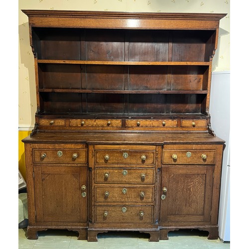 76 - Georgian oak dresser with break front base on bracket feet, four central drawers flanked by two cupb... 