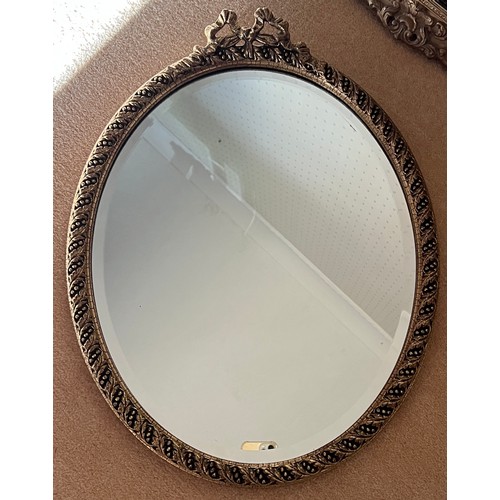 1015 - A gilt framed bevel edged oval wall mirror. 58cm x 44cm.