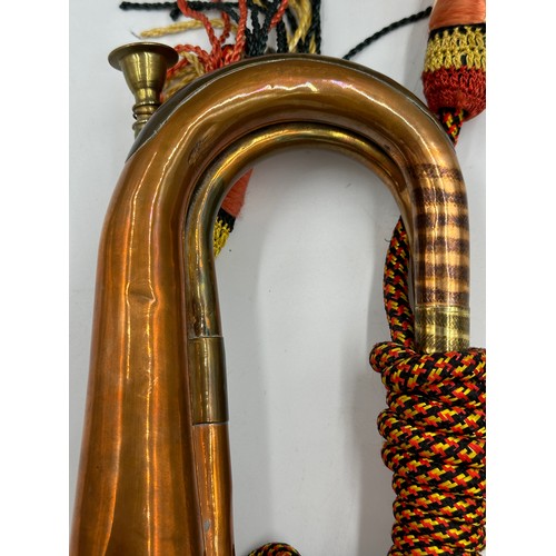 916 - A British Army Royal Artillery brass and copper bugle with yellow, black and red cord tassel and Roy... 