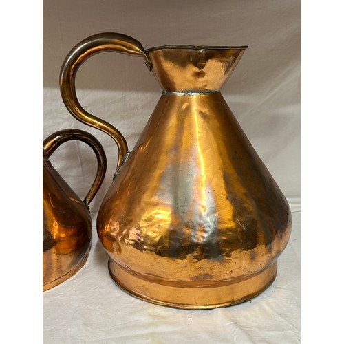 909 - A collection of three large antique copper jugs: 4 gallon, 2 gallon and half gallon approx. 43cm h.