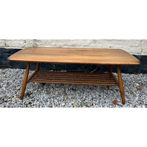 89 - Ercol coffee table with magazine rack to base. 105cm l x 46cm w x 35cm h.