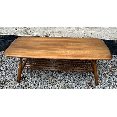 89 - Ercol coffee table with magazine rack to base. 105cm l x 46cm w x 35cm h.