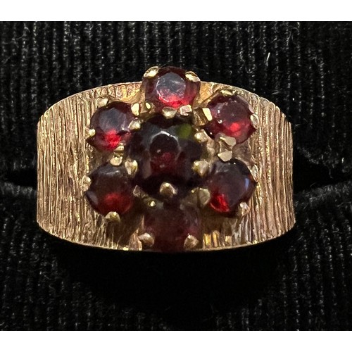 453 - A 9 carat gold bark effect ring set with garnets. Size L. Weight 4.2gm.