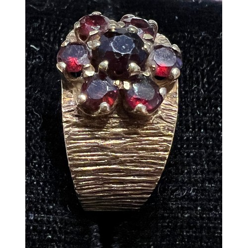 453 - A 9 carat gold bark effect ring set with garnets. Size L. Weight 4.2gm.