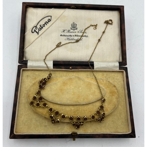 474 - A gem set necklace in yellow metal in leather,  silk and velvet presentation case. Length 41cm.