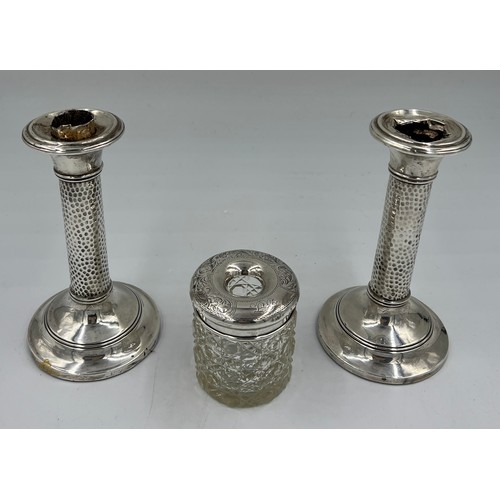 726 - Two silver candlesticks with planished stems and weighted bases, Birmingham 1906, maker CB, possibly... 