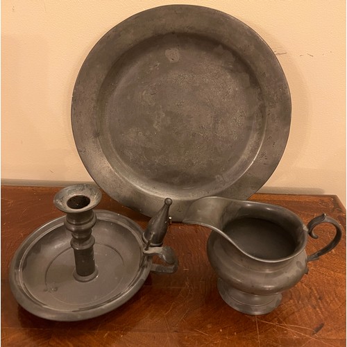 907 - Pewter to include plate 27.5cm d, chamber stick and snuffer and a jug.