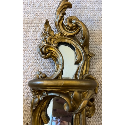 1019 - A pair of 19thC decorative wooden gilt wall mirrors with galleried shelves with bird and floral deco... 