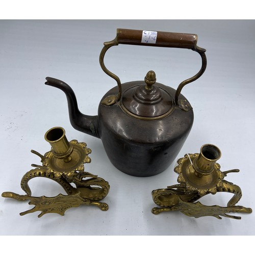 908 - A 19thC heavy copper kettle with acorn knop together with a pair of brass Griffin candlesticks 17cm ... 