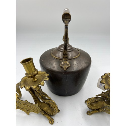 908 - A 19thC heavy copper kettle with acorn knop together with a pair of brass Griffin candlesticks 17cm ... 